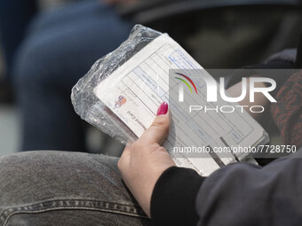 An Iranian woman holds a Vaccination Record Card as she waits to receive a dose of the new coronavirus disease (COVID-19) vaccine during the...