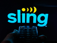 TV remote control is seen with Sling logo displayed on a screen in this illustration photo taken in Krakow, Poland on February 6, 2022. (