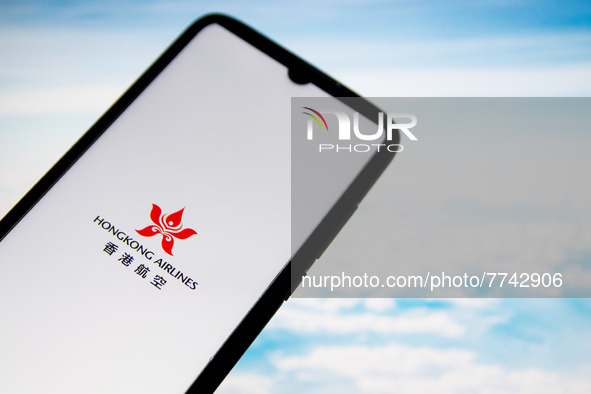 In this photo illustration a Hong Kong Airlines logo seen displayed on a smartphone screen with a computer wallpaper in the background in At...