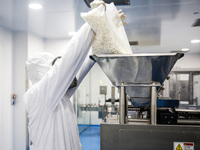 Laboratory technicians wearing full face masks and protective suits work to produce molnupiravir, the first tablet drug used to treat corona...