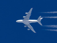 Qatar Airways Airbus A380 double decker aircraft overfly at 40.000 feet in the blue sky during a sunny day over Europe, performing a flight...