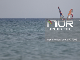 Two windsurfers practice near Kos island, in Kos, on September 10, 2015. The head of the European Union's executive says 22 of the member st...