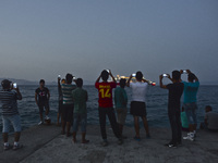Group of migrants photograph approaching ferry that will take nearly 1000 of migrants from Kos island to Athens, in Kos, on September 10, 20...
