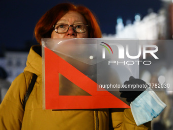 A woman holds a red set square banner while demonstrating during 'Stop Lex Czarnek' protest at the Main Square in Krakow, Poland on February...