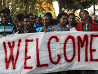 Demonstrators hold a banner reading 'Welcome' as they take part in a demonstration in solidarity with refugees seeking asylum in Europe afte...