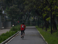 A woman rides her bicycle at Benchakitti park on February 17, 2022 in Bangkok, Thailand. (