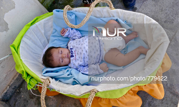 An 8 week old baby waits by the police station with his mother. According to the UNHCR the number of Syrians who have fled is approaching 4...