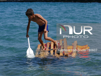 A Syrian boy plays with a makeshift raft as he paddles around the shores of the Greek island of Kos. The boy has made the trecerous night jo...