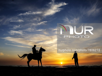 A Palestinian man rides his horse in front of Gaza beach during sunset, on February 22, 2022.  (