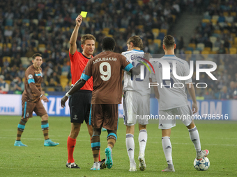 Referee Felix Brych shows a yellow card during the UEFA Champions League Group G stage football match between FC Dynamo Kyiv and FC Porto at...