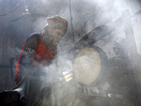 Worker works in dust environment inside in a utensil factory while sunrays enter through the rooftop in Dhaka, Bangladesh on March 08, 2022....