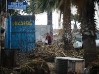 A woman searches amid the debris left by the tsunami that ensued an 8.3 quake that left 12 people dead and five more missing, in Coquimbo, 4...