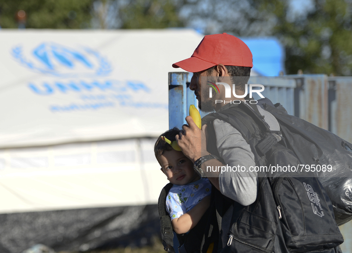 A young migrant and his father arrive at the transfer camp in Opatovac near border crossing point between Serbia and Croatiain Opatovac, Cro...