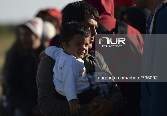 A young migrant and his som arrive the temporary transfer camp in Opatovac near border crossing point between Serbia and Croatiain Opatovac,...