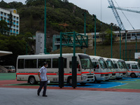 A driver looks at the ambulance buses which are parked on a basket ball terrain near the United Christian Hospital in Kwun Tong, in Hong Kon...