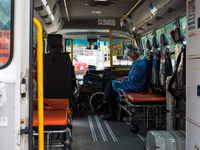 A paramedic checks his phone while waiting in an ambulance bus to transfer patients at United Christian Hospital, in Kwun Tong, in Hong Kong...