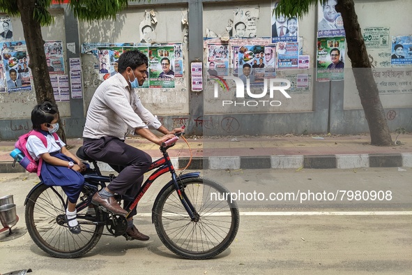Father taking his child to school on a bicycle in Dhaka, Bangladesh on 27th March, 2022. 