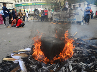 Left Democratic Alliance activists set fire to a tire and block a road during the countrywide half-day strike in protest against the price h...