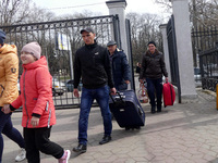 ODESA, UKRAINE - MARCH 29, 2022 - Evacuees from Mykolayiv carry luggage to the station upon their arrival to Odesa, southern Ukraine (