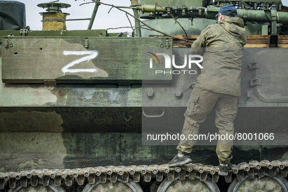 Ukrainian soldier in a captured armored vehicle with the symbol Z of the russian army in Kharkiv, Ukraine. 
