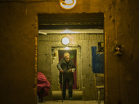 An old woman prepares her food inside a shelter in the basement of her home in Kharkov, Ukraine. (