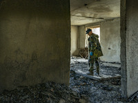 A militia member stands inside the ruins of a flat destroyed by russian artillery during the combats between the russian and ukrainian armie...