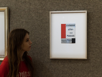 LONDON, UNITED KINGDOM - APRIL 04, 2022: A staff member looks at a typographical poster for 'G. Vantongerloo Sztuka I Jej Przyszlosc Wydawni...