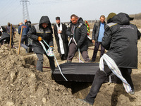 DNIPRO, UKRAINE - APRIL 1, 2022 - Men lower a coffin into a grave during the funerals of soldiers killed during the Russian invasion of Ukra...