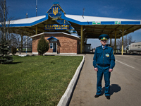 Ukrainian Customs Service officer stands in front of the Starokozache border crossing point on the border between Ukraine and Moldova (