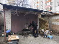 A woman is preparing a meal on fire next to apartments blocks in the recaptured by the Ukrainian army Bucha city near Kyiv, Ukraine, 04 Apri...