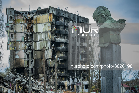 Taras Shevchenko bust in the city of Borodianka, with a shelled building in the background destroyed during the combats between the russian...