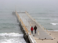 People walk at the Black Sea coast of the city of Odesa, Ukraine on 6 April 2022. (