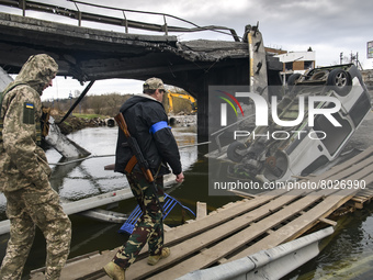 Ukrainian servicemen cross the Irpin river near a destroyed bridge outside the recaptured city of Irpin, Ukraine, 06 April 2022 (