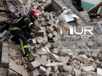 KYIV REGION, UKRAINE - APRIL 06, 2022 - A rescuer clears the debris at the site of a multi-story residential building destroyed by russian a...