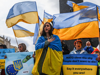 Ukrainian citizens and supporters sing Ukrainian anthem while attending a demonstration of solidarity with Ukraine at the Main Square, deman...