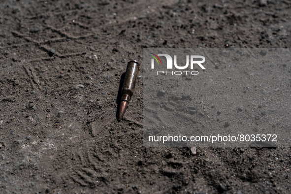 BUCHA, UKRAINE - APRIL 7, 2022 - A cartridge lies on the ground after the liberation of the city from Russian invaders, Bucha, Kyiv Region,...