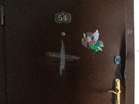 BUCHA, UKRAINE - APRIL 7, 2022 - A cross is chalked on the door to an apartment after the liberation of the city from Russian invaders, Buch...