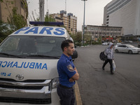 A health personnel stands next to an ambulance on a corner of a square in Tehran during a polluted air, on April 8, 2022. (
