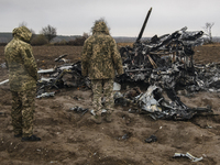 Ukrainian servicemen inspected the fragments of a Russian military helicopter Mi-8 near Makariv, Kyiv area, Ukraine, Saturday, April 9, 2022...
