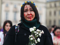 A woman painted with fake blood attends a silent protest at the Main Square against the mass murder of Ukrainian civilians by the Russian so...