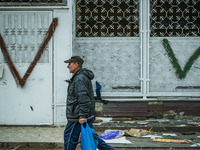 A man walks in the streets of Borodianka city surrounded of V sym bols that russian troops painted during its occupation of the city in the...
