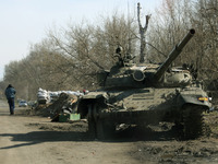 KYIV REGION, UKRAINE - APRIL 07, 2022 - A tank and a checkpoint on the side of the road as traces of the russian military invasion, Kyiv Reg...