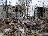 KYIV REGION, UKRAINE - APRIL 07, 2022 - Residential buildings damaged in the result of the russian military invasion are seen bihind a pile...
