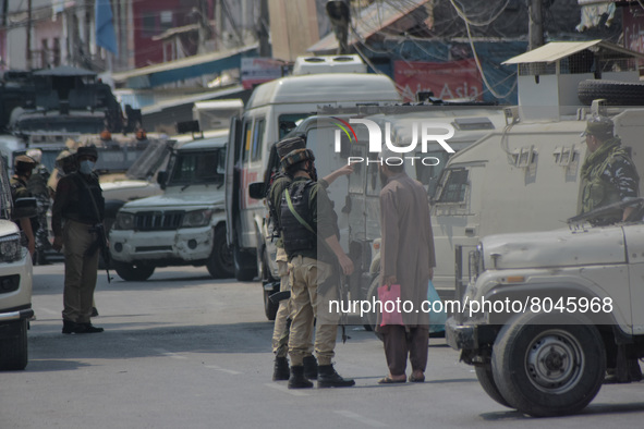 Indian paramilitary troopers stop a civilian near the encounter site in in Srinagar, Indian Administered Kashmir on 10 April 2022. Two forei...