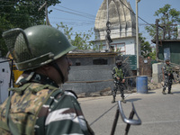 Indian paramilitary troopers stand near the encounter site in in Srinagar, Indian Administered Kashmir on 10 April 2022. Two foreign militan...