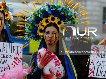 People hold placards and blood splattered fake-babies at a protest in support of Ukraine outside the gates of Downing Street in London, Brit...