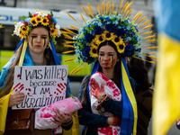 People hold placards and blood splattered fake-babies at a protest in support of Ukraine outside the gates of Downing Street in London, Brit...