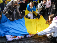 Women put Ukrainian flag on the handmade baby bundles resembling Ukrainian newborn children while attending 'Mothers' March' as part of Stan...