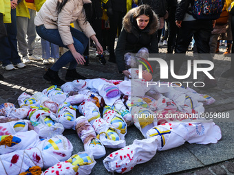Women put on the gorund handmade baby bundles resembling Ukrainian newborn children while attending 'Mothers' March' as part of Stand with U...