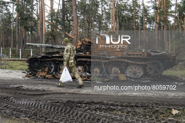 Ukrainian serviceman goes past destroyed Russian military tank near Berezivka village,  close to Kyiv, Ukraine, Monday, April 11, 2022 